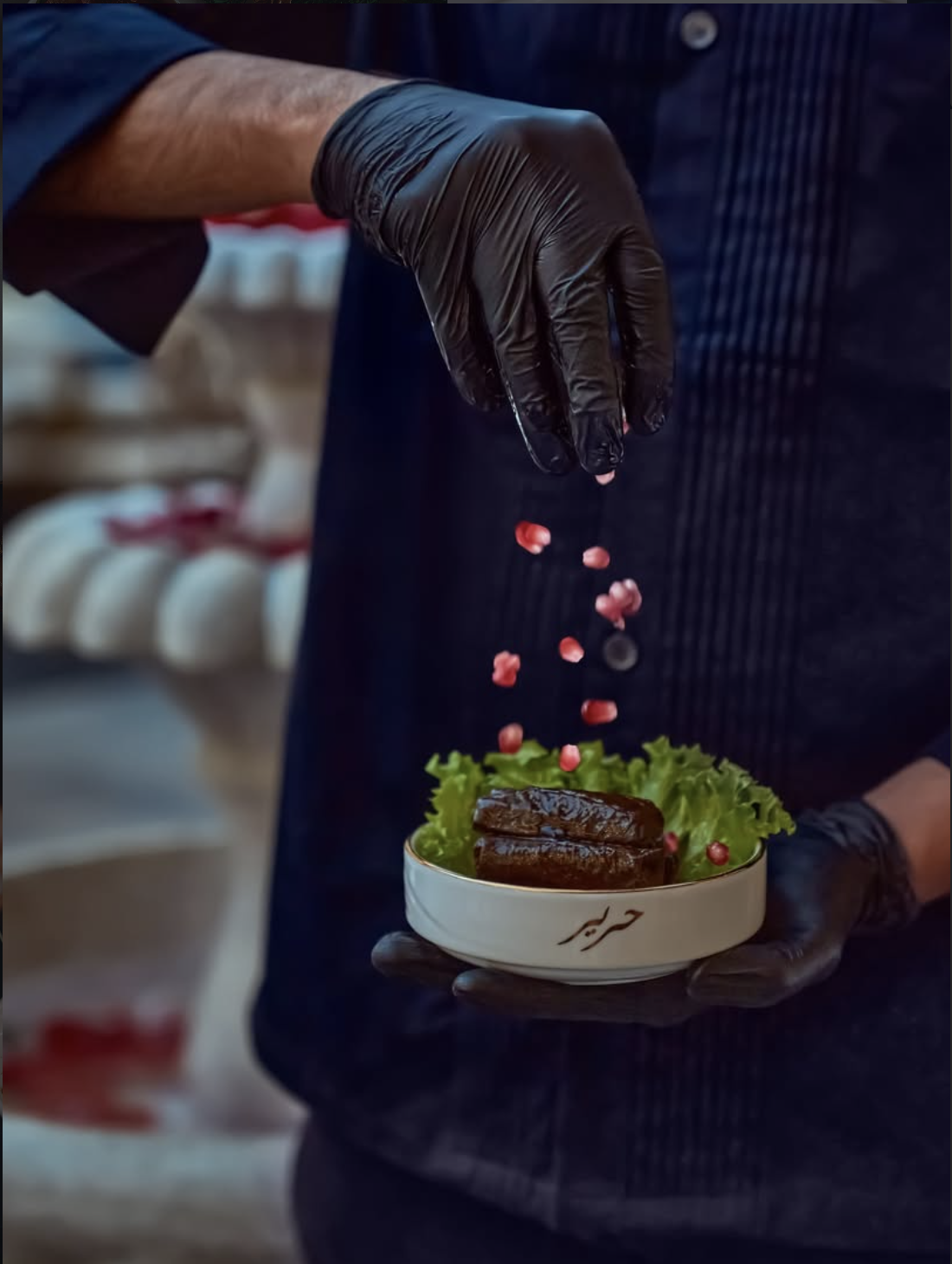 Chef preparing signature dish with pomegranate